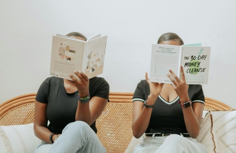 Two people reading side by side, comfortable in the quiet