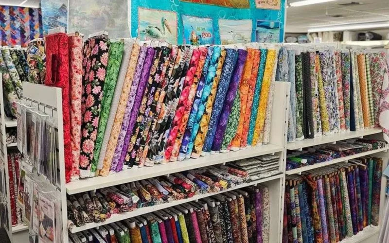Colorful quilting cotton bolts stacked on shelves in a Florida fabric store