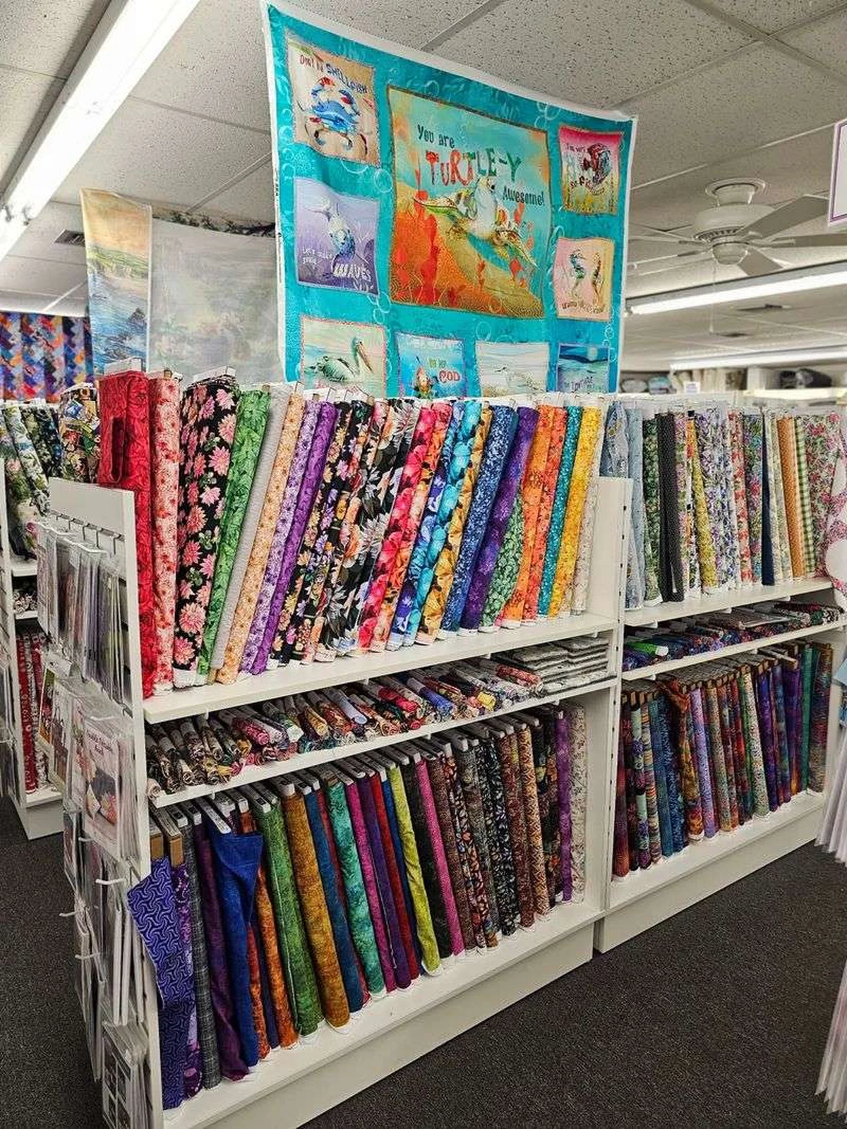 Colorful quilting cotton bolts stacked on shelves in a Florida fabric store