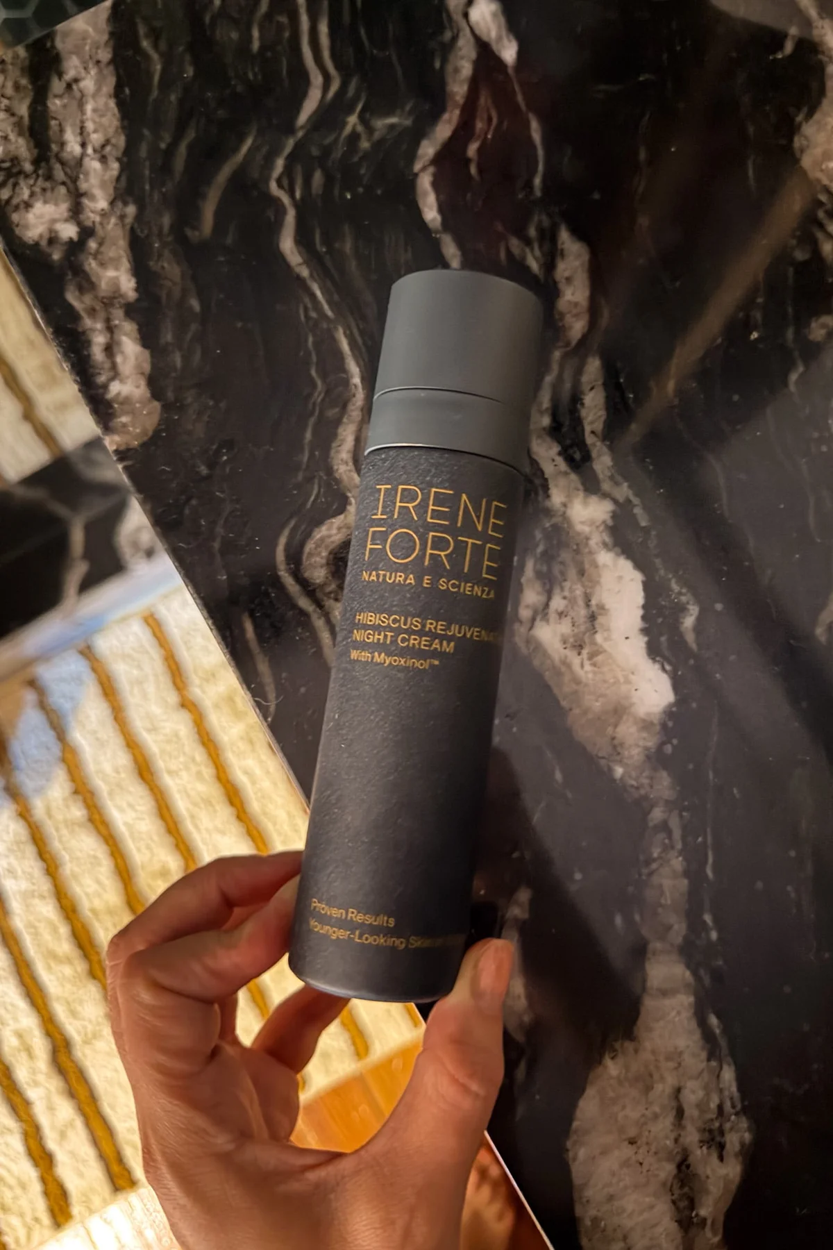Hand holding Irene Forte Hibiscus night cream bottle