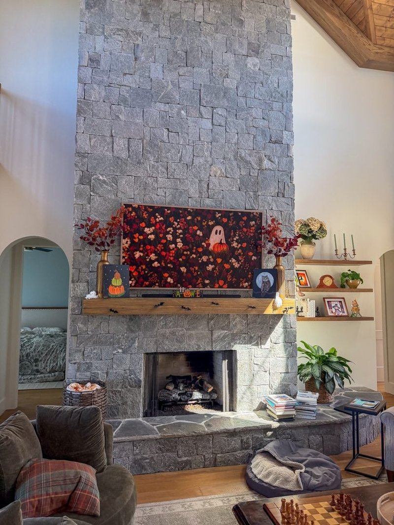 Gray stone fireplace with wooden mantel in a living room